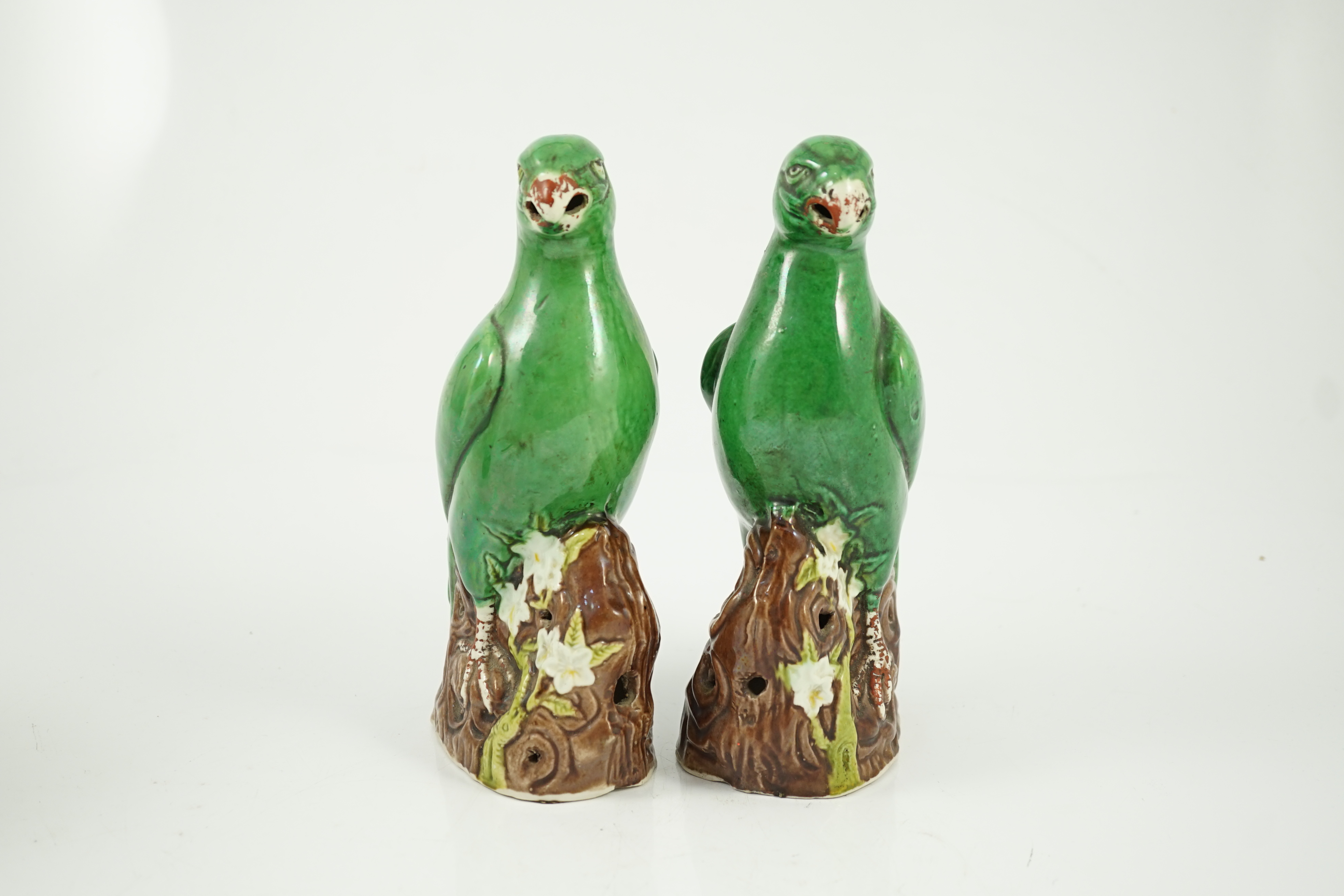 A pair of Chinese green glazed models of parrots, Kangxi period, hairline cracks to one tail feather